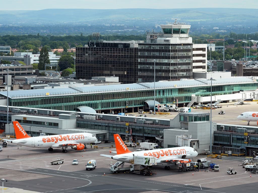 Manchester Airport terminal with aircraft at the gates and control tower