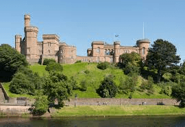 White manor house with formal gardens and wedding couple on stone steps near Inverness